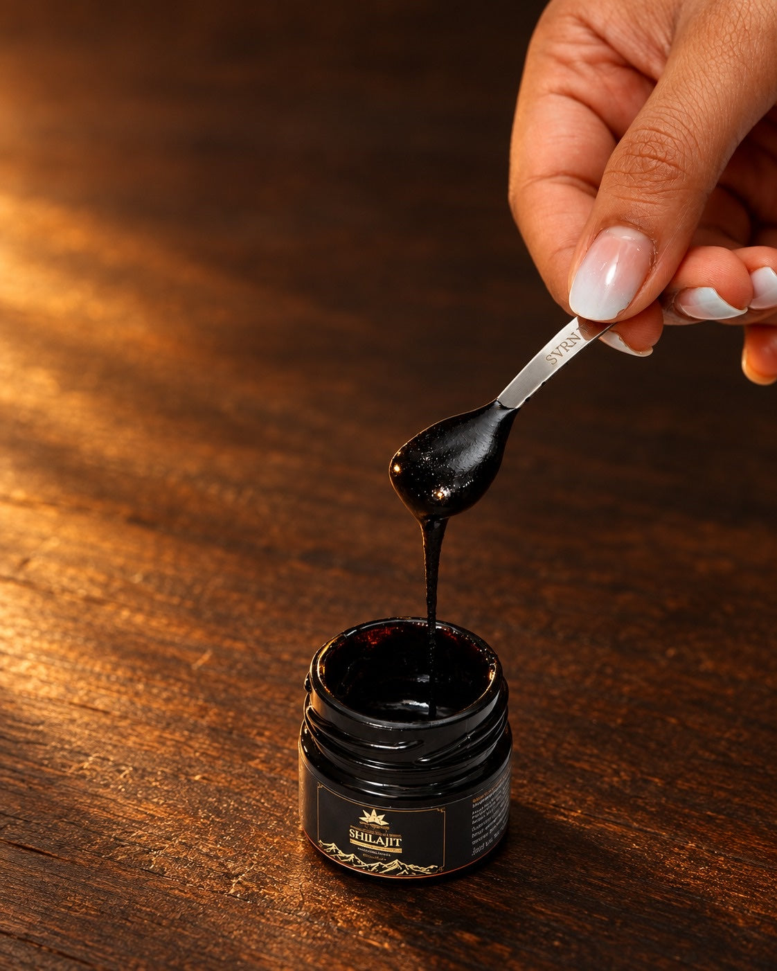 SVRN shilajit resin lifted from the open jar with the serving spoon